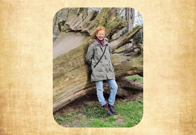 Ute an einem Baumstamm lehnend